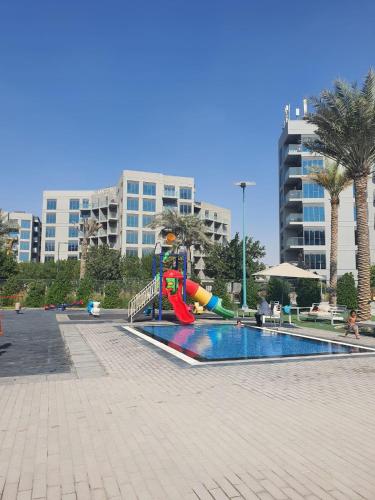a playground with a slide in a park at Cozy 1-bedroom apartment in Dubai South with Pool in Dubai