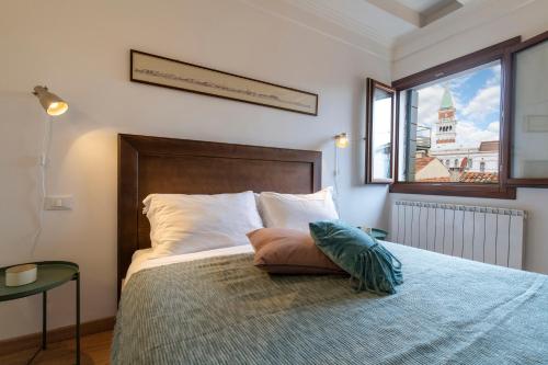 a bedroom with a bed with a large window at San Marco Schiavoni apartments in Venice