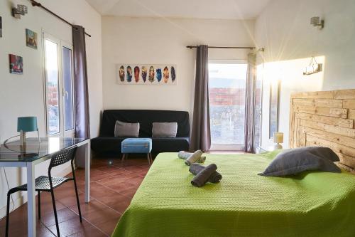 1 dormitorio con 1 cama verde y 1 sofá en Da Mata Kite&Surf House, en Lajares