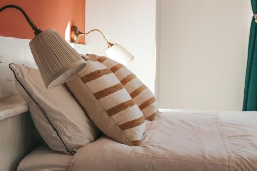 a bed with two pillows and a lamp on it at Casa di Franz in Vigo di Fassa