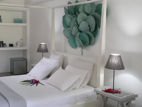 1 cama blanca con almohadas blancas y una pintura en la pared en South House-Weligama, en Weligama