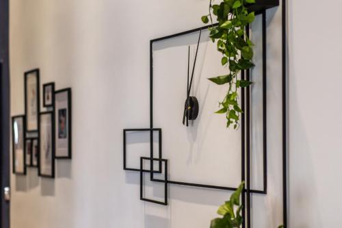 a wall with framed pictures and a plant at De Pejoto in Tel Aviv