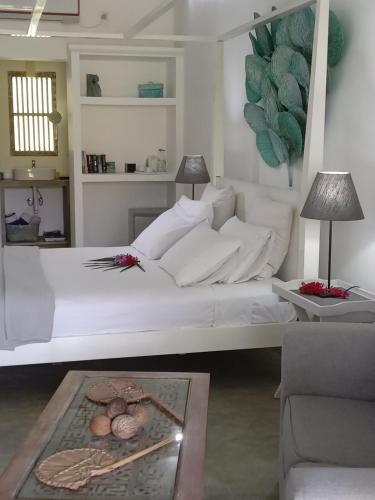 a bedroom with a white bed and a table at South House-Weligama in Weligama
