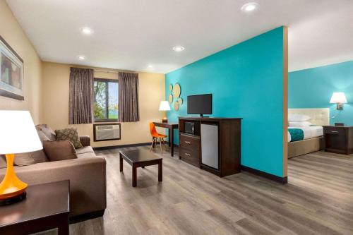 a hotel room with a couch and a bed and a tv at Howard Johnson by Wyndham Waterloo/Cedar Falls in Waterloo