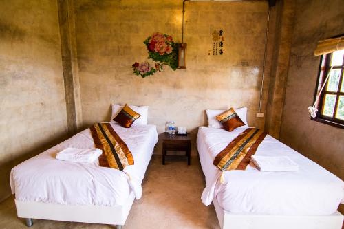 a room with two beds and a table in it at My Place Mae Salong in Ban A Ku