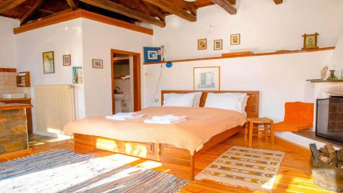 a bedroom with a large bed and a fireplace at Chrissi Nefeli in Agios Georgios Nilias