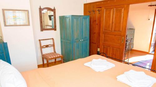 a bedroom with a bed and a blue cabinet at Chrissi Nefeli in Agios Georgios Nilias