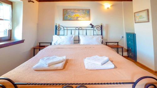 a bedroom with a large bed with two towels on it at Chrissi Nefeli in Agios Georgios Nilias