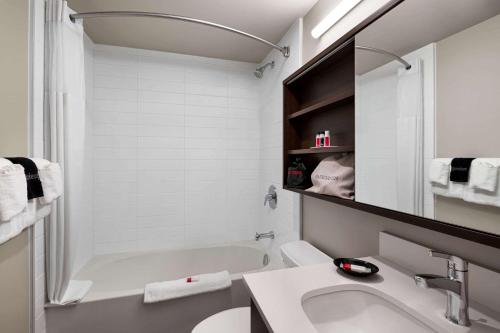 a white bathroom with a tub and a sink at Microtel Inn & Suites by Wyndham Antigonish in Antigonish