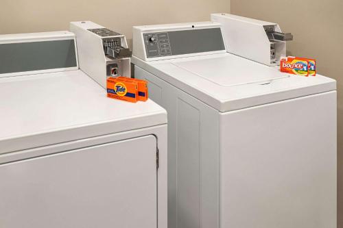 two microwaves on top of a washer and dryer at Microtel Inn & Suites by Wyndham Antigonish in Antigonish