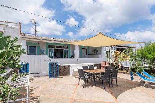 a patio with a table and chairs in front of a house at Villa Mareblu Luxury Holiday Apartment direttamente sul mare in Stromboli