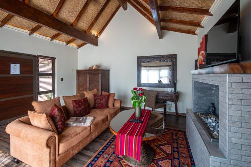 a living room with a couch and a fireplace at The Zarafa in Hazyview