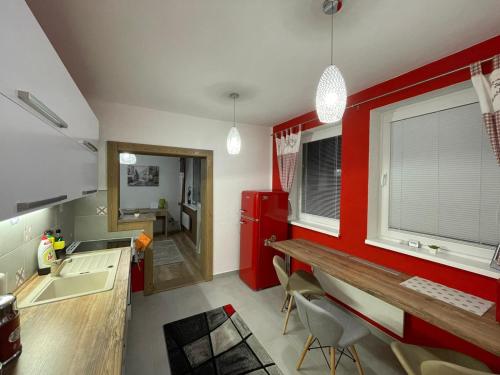 a kitchen with red walls and a sink and a counter at Style Apartment Telgart in Telgárt