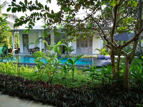 a house with a swimming pool in a garden at South House-Weligama in Weligama