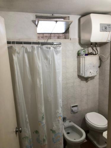 uma casa de banho com um WC e uma cortina de chuveiro em La Susy em Salto