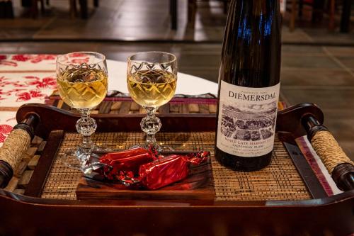 a bottle of wine and two glasses on a table at The Zarafa in Hazyview