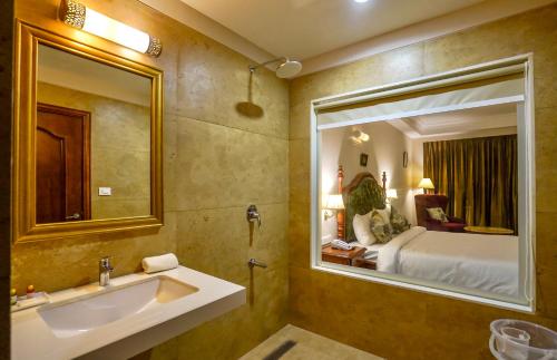 a bathroom with a sink and a large mirror at Ranbanka Heritage Resort 1 km from Bhilwara Railway Station in Bhilwara