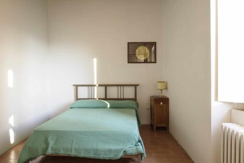 sypialnia z łóżkiem z zielonym kocem w obiekcie CASA LELLA Monte San Pietrangeli w mieście Monte San Pietrangeli
