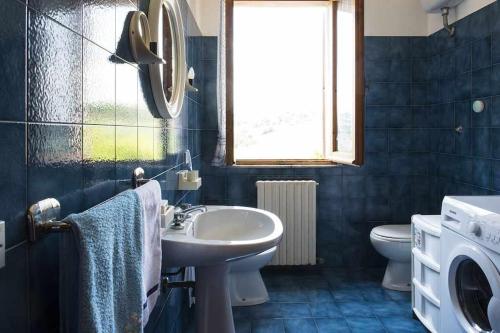a bathroom with a sink and a toilet and a window at LA CASA DE FASCIA' Contrada pescara valle in Monte San Pietrangeli