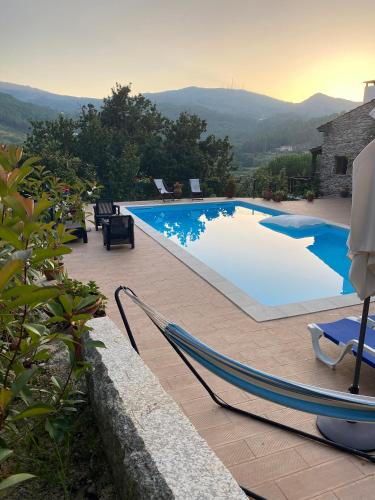 a large swimming pool with chairs on a patio at Villa de Fujacos in Valença