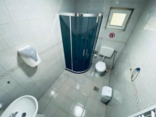 uma casa de banho com um chuveiro, 2 WC e um lavatório. em Bus Station Hostel em Pristina