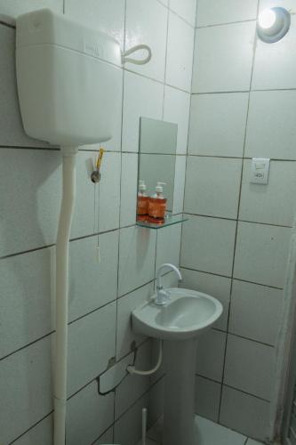 a white bathroom with a sink and a mirror at Ótima Suíte - Ponta Negra in Natal