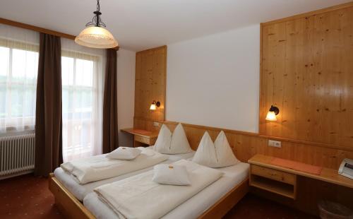 een slaapkamer met 2 bedden en witte kussens bij Alpenperle in Ramsau am Dachstein