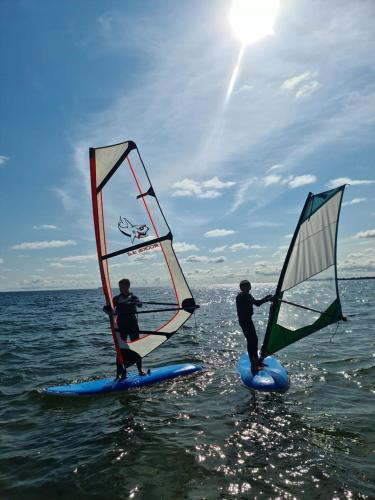 two people on surfboards with sails on the water at Sopot 34 przy plaży in Sopot
