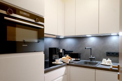 a kitchen with white cabinets and a sink at Apartment 10 an der Rottach in Rottach-Egern