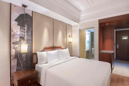 a bedroom with a large white bed in a room at Radisson Kufri in Shimla