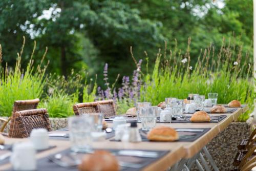 a long wooden table with food on top of it at Les Jardins de l'Anjou in La Pommeraye