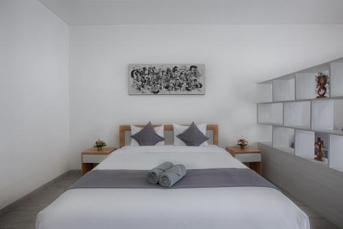 a bedroom with a large white bed with two pillows at Maisaba Canggu Hotel & Coworking Space in Canggu