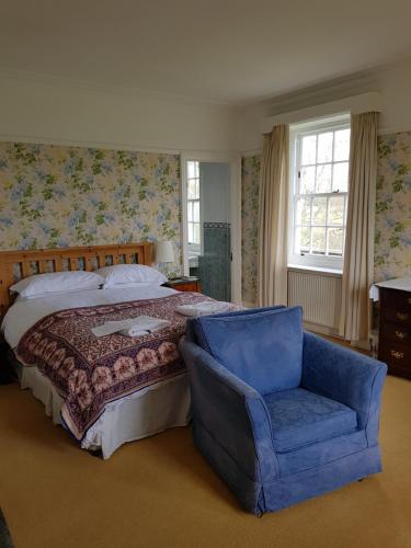 a bedroom with a bed and a blue chair at Clift Hill in Carlisle