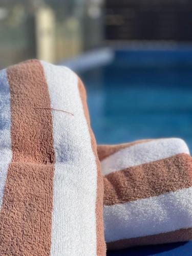 a close up of a striped couch next to a pool at Grand Tourist Hotel in Muscat