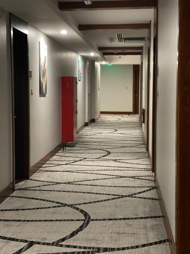 a hallway of an office building with a carpet on the floor at Grand Tourist Hotel in Muscat