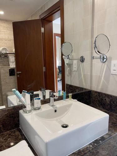 a bathroom with a white sink and a mirror at Grand Tourist Hotel in Muscat