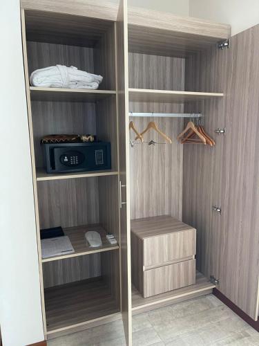a closet with wooden shelves and acomputer in it at Grand Tourist Hotel in Muscat