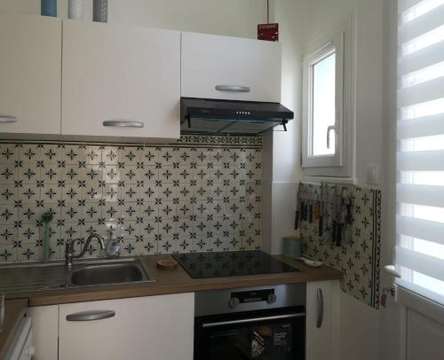 une cuisine avec un évier et une cuisinière dans l'établissement Notre Dame de la Mer, à Cayeux-sur-Mer