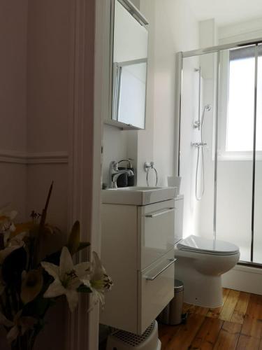 une salle de bain blanche avec des toilettes et un lavabo dans l'établissement Notre Dame de la Mer, à Cayeux-sur-Mer