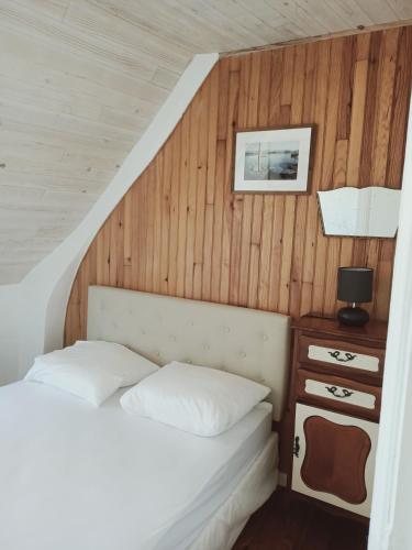 une chambre avec un lit et un mur en bois dans l'établissement Notre Dame de la Mer, à Cayeux-sur-Mer