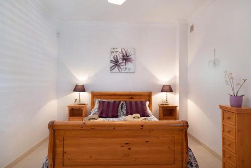a bedroom with a wooden bed and two night stands at Villa Carolina in Tías