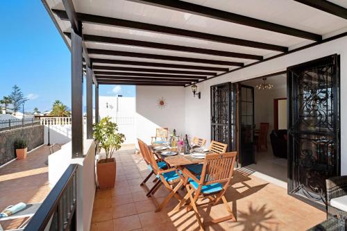 a patio with a table and chairs on a balcony at Villa Carolina in Tías