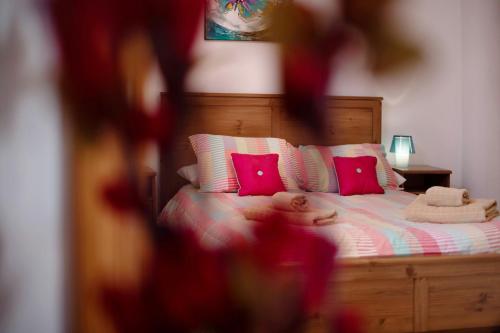 a bed with pink pillows and a teddy bear on it at Villa Carolina in Tías