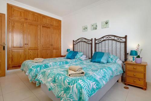 a bedroom with two beds with blue pillows on it at Villa Carolina in Tías