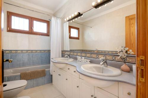 a bathroom with two sinks and a tub and a toilet at Villa Carolina in Tías