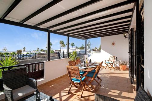 a patio with a table and chairs on a balcony at Villa Carolina in Tías
