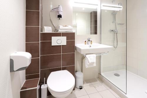a bathroom with a toilet and a sink and a shower at Hôtel des Halles in Dijon