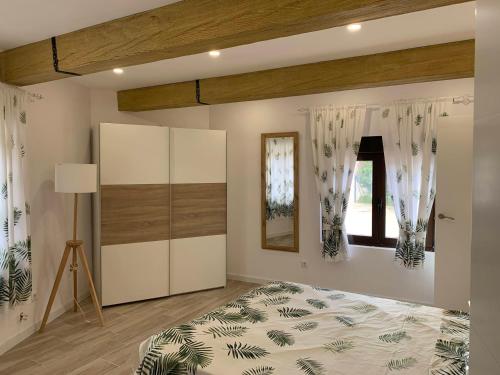 um quarto com uma cama e uma janela em Alojamiento con amplio salón y chimenea. em Valverde
