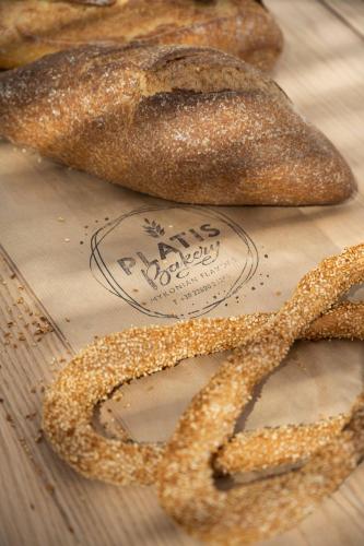 a group of breads on a wooden table with a pretzel at Argo Hotel in Platis Yialos Mykonos