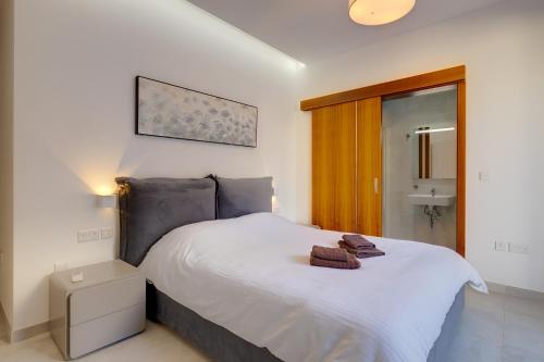 a bedroom with a white bed with towels on it at Superlative Apartment with Valletta and Harbour Views in Sliema